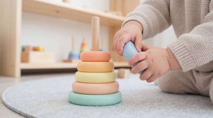 Small hands playing with pastel stacking rings