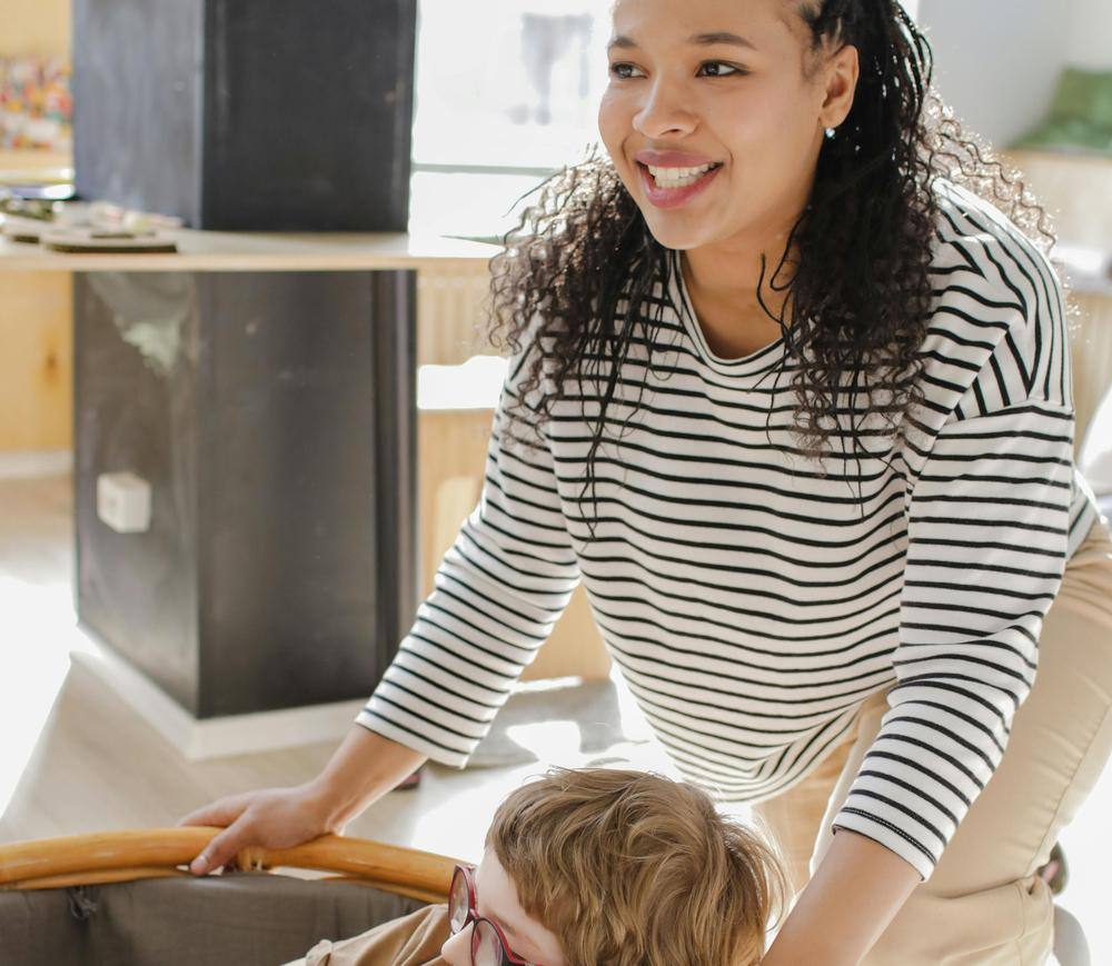 A smiling caregiver playing with a child indoors
